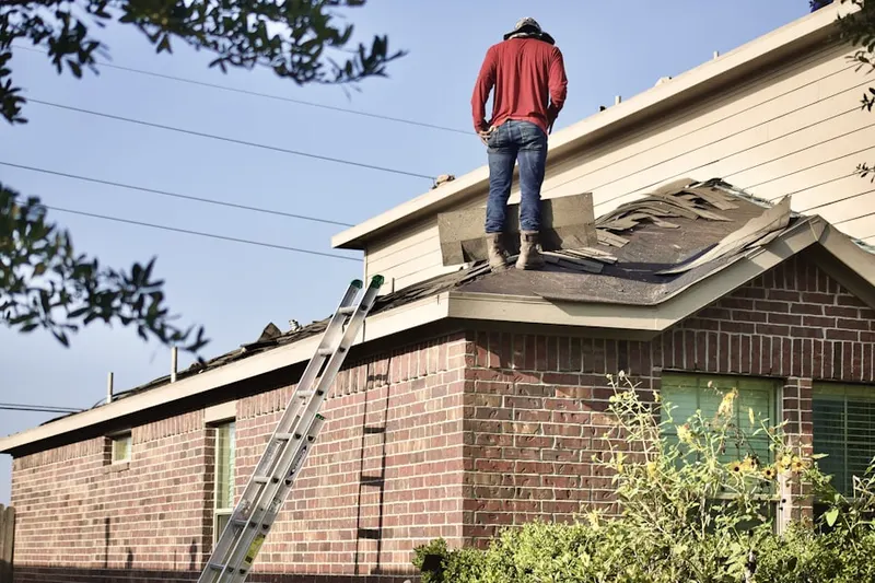 Professional roofer working on a residential roof in Lucon